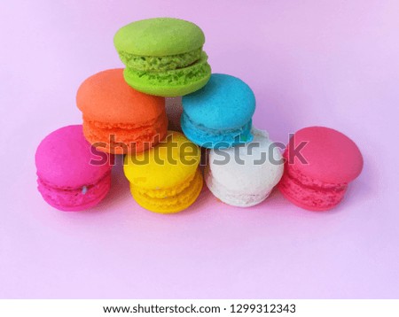 Delicious macaron place the shape like a pyramid on pink background, colorful macaroon arranged in layers