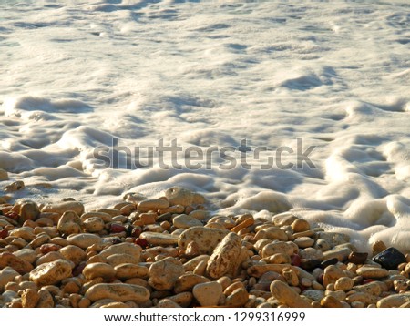 Frothy wave and sea pebble stones on the Black sea coast