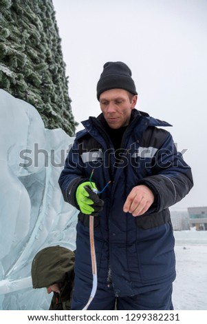 Electrician cleans the ends of the power cable to illuminate the ice figures