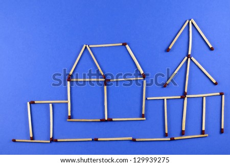 Matchsticks. House with tree on blue background.