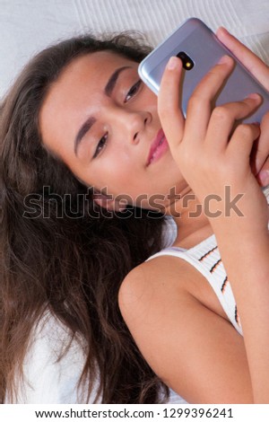 Young girl texting on a smart phone - Stock image