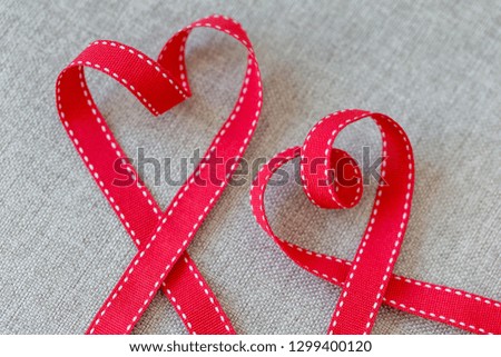 Hearts made from red ribbon on linen textile, Valentine's Day concept