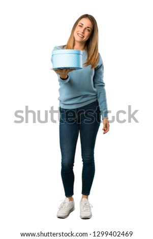Full body of Blonde woman with blue shirt holding a gift in hands on white background