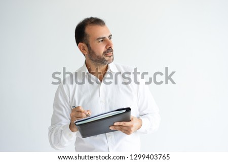 Pensive handsome man holding file and writing. Business man thinking and working. Paperwork concept. Isolated front view on white background.