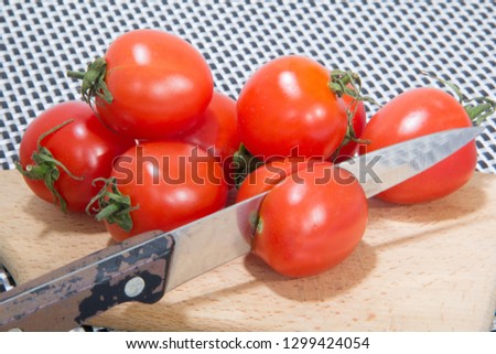Picture of cherry tomatoes with a knife stuck in them, concept, isolated.