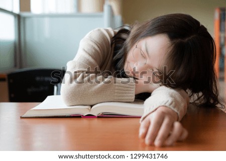 Sleeping woman in library. Woman study hard and asleep in an university library. Education concept.