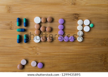 the inscription of "help" from the colored pill