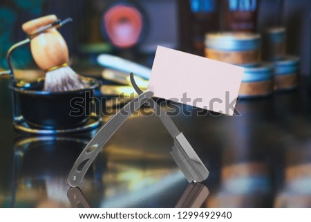 razor with a business card on the background of hairdresser's tools