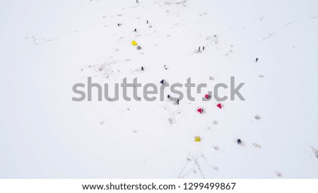 Aerial view of winter fishing. Fishermen set up tents for fishing at night.