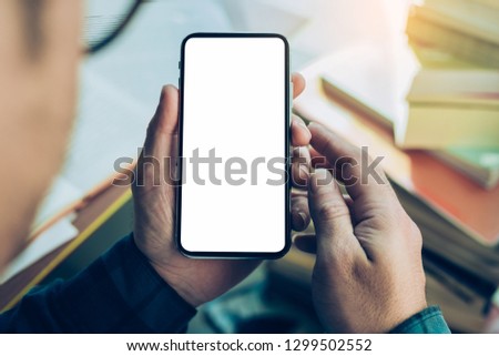 mockup image of cell phone.Businessman at workplace Think business investment plan.Contact Investor using mobile,computer.make note appointment information in the notebook.design creative work space
