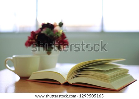 Close-up of open books on the desk flower pot as background selective focus and shallow depth of field