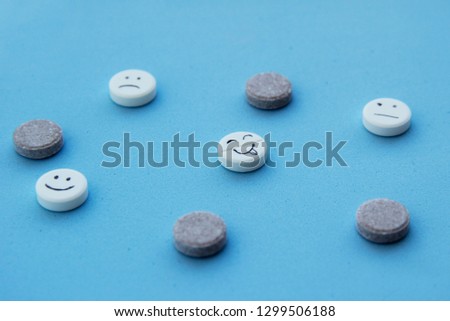 Tablets on a blue background with emoticons. medicine tablets. Funny faces on the tablets