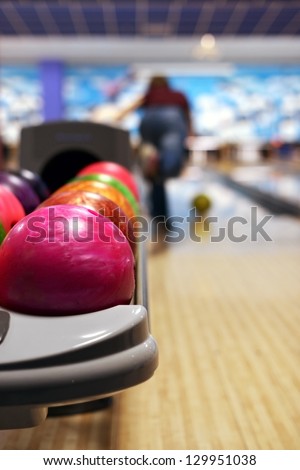 Bowling ball machine with person bowling in the background