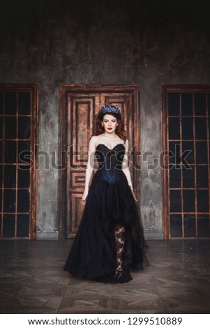 Portrait of a stunning fashionable model in corset and crown in studio