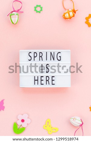 Creative Top view flat lay holiday composition Easter text Spring is here on lightbox pink paper background copy space Template Easter day seasonal pattern