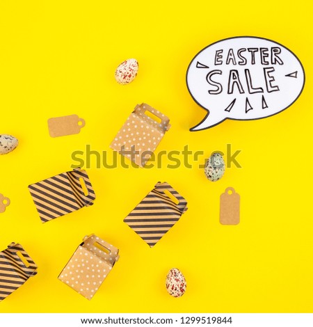 Creative Top view flat lay holiday promo composition Easter sale bunny ears gift boxes eggs text message on bold yellow paper background copy space Template Easter day seasonal minimal concept