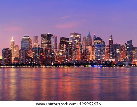 New York City Manhattan downtown skyline at dusk with skyscrapers illuminated over Hudson River panorama