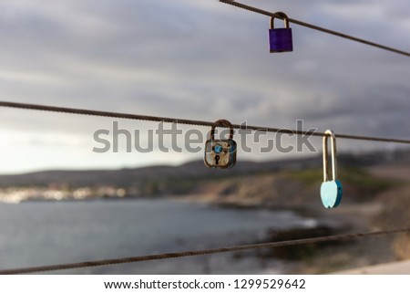 Love padlocks on beach walk railing in Meloneras, Gran Canaria. Three locks hanging from cable with sea on background. Tradition memory, union concepts