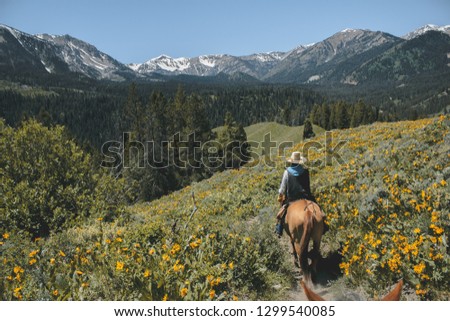 Horseback riding in the Grand Teton Mountain Range Royalty-Free Stock Photo #1299540085