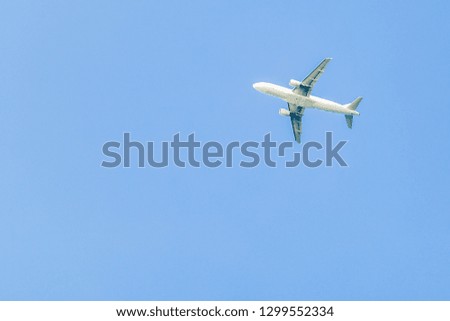 passenger white airplane picture against the background of a pure summer blue sky sky is high.
an airplane that dips to land or climbs altitude after takeoff