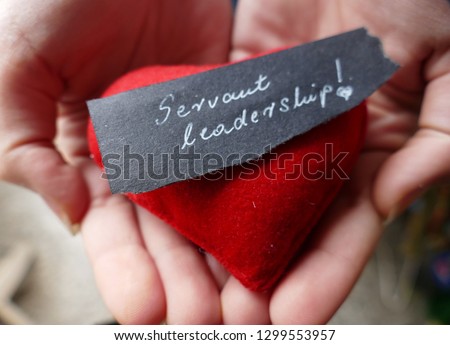 Servant leadership - open hands with red heart and note  Royalty-Free Stock Photo #1299553957