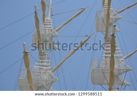 Masts of ship sailboat with fold on the background blue skyed sails occupying the whole setting in vertically