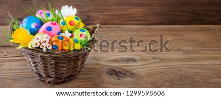 Easter eggs in basket and wooden background
