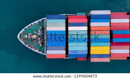 Aerial of cargo ship carrying container and running for export  goods  from  cargo yard port to other ocean concept freight shipping ship on blue sky background.