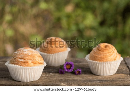 Close up fresh baked golden muffins and biscuit on rustic wooden background shot in natural light