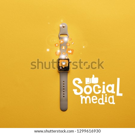 top view of smartwatch with icons and social media lettering on yellow surface