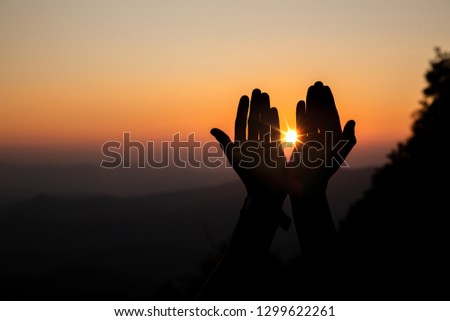 Lift hands to worship God with light sunset background. christian silhouette concept.