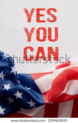 top view of united states of america flag and yes you can lettering on white surface 