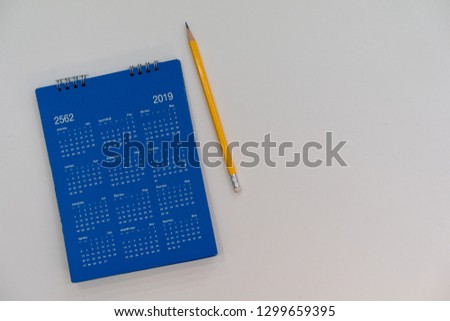 close up blue color calendar 2019  lay on white table at office room for make appointment or remind important date , workplace with object concept