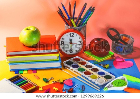 stationery accessories - pens, markers, paints, scissors, stickers, notepads. clock and apple.