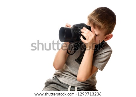 Boy takes pictures on the camera. Portrait. Isolate on white background.