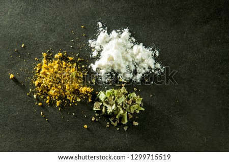 various spices scattered on a dark surface