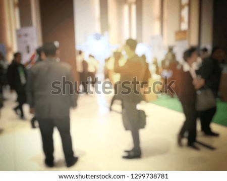blurred image of people walking on a trade fair exhibition or expo where business people show innovation activity and present product in a big hall.