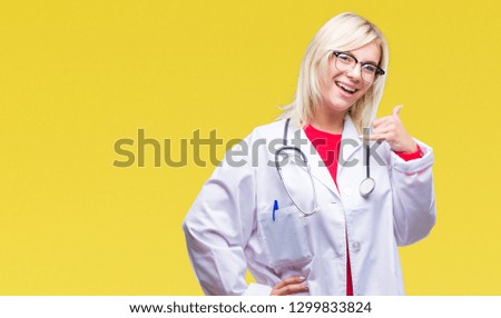 Young beautiful blonde doctor woman wearing medical uniform over isolated background smiling doing phone gesture with hand and fingers like talking on the telephone. Communicating concepts.