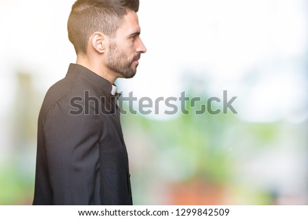 Young Christian priest over isolated background looking to side, relax profile pose with natural face with confident smile.