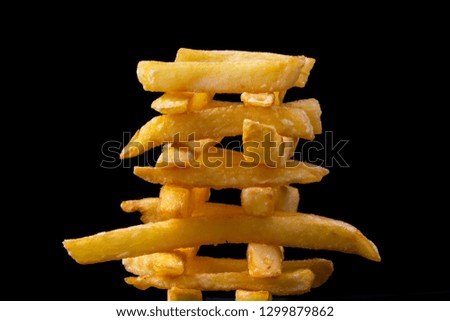 appetizing french fries in the form of pyramids on a black background