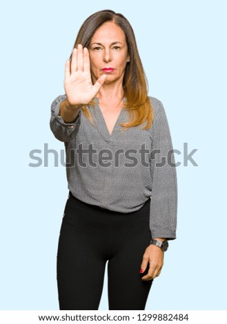 Beautiful middle age business woman doing stop sing with palm of the hand. Warning expression with negative and serious gesture on the face.