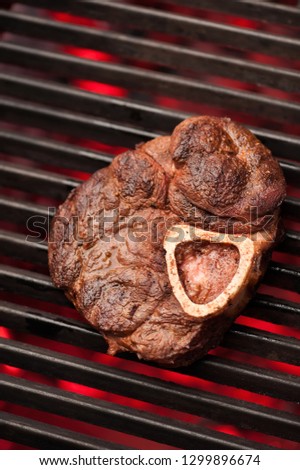 Grilling steak on the flaming grill, close-up, selective focus, vertical shot. Photo taken on workshop.
