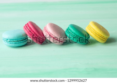 Sweet and colourful french macaroons on mint background 