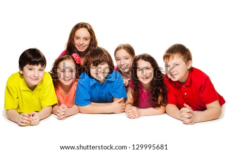 Large group of boys and girls laying on the floor together, smiling and happy, isolated on white Royalty-Free Stock Photo #129995681