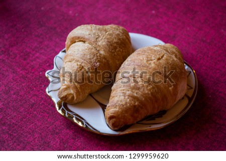 The croissants in a plate on a table, close up.