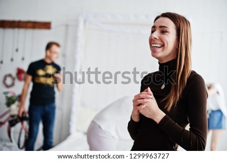 Girl laughing against  photographer in work at studio.
