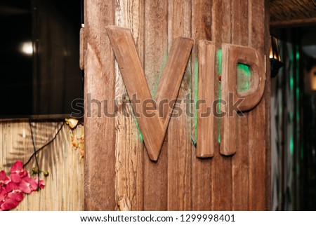 VIP lettering on wood door, green light. Spa salon interior photography