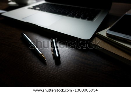 Close up office desk table with laptop, note book, mobile coffee and pen. Selective focus. Business concept. Copy space. 