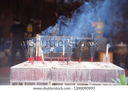 Smoke from many incense sticks that are embroidered on large square pots on the back is religious places, pollution problems from faith.