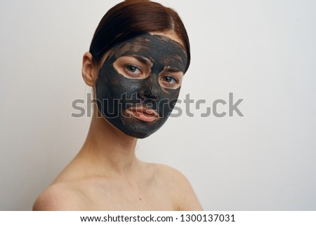serious woman in clay face mask portrait